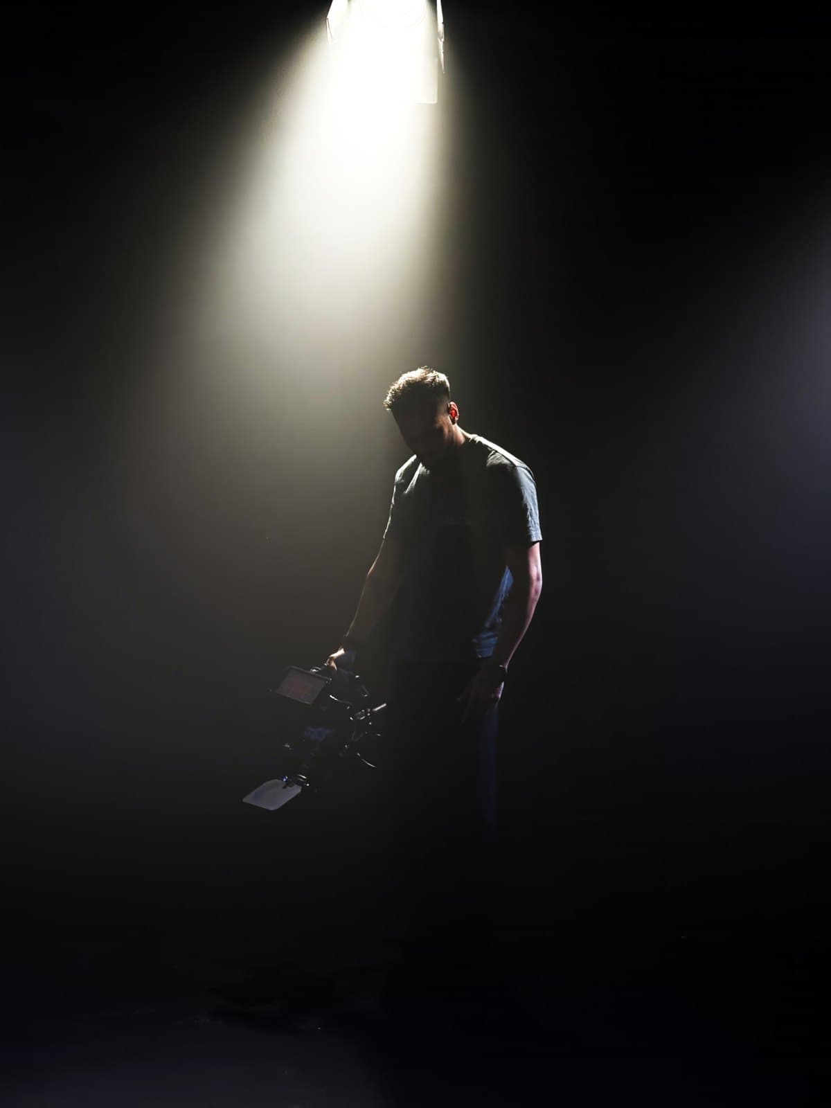 Rohan Nambiar under a spotlight, holding a camera rig